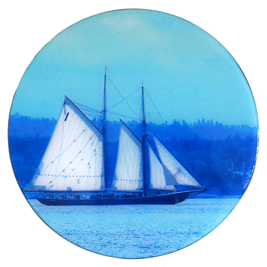 Bluenose II, the internationally renowned schooner, designed and constructed in Lunenburg, Nova Scotia, gliding along the tranquil waves of Blue Rocks Harbour. It is a perfect piece of art to add to any room. This beautiful round wood panel features unique Bluenose photography coated with resin, measuring 8 inches in diameter. Ready to hang on the wall, this piece will add a touch of originality to your home.