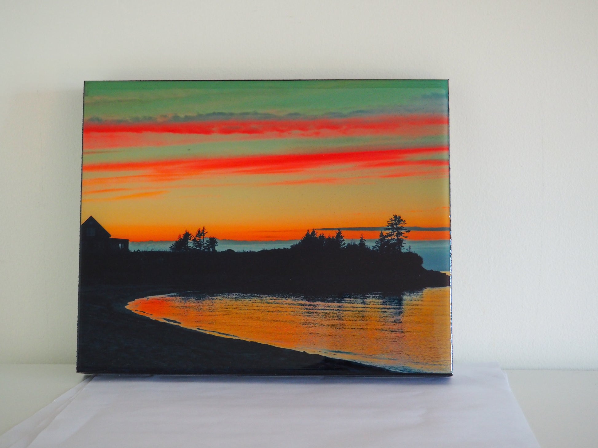 Vibrant hues of turquoise, pyroll orange, and crimson red illuminate Toney River's sunset. Colors blend to create a beautiful and calming effect.  This 8 x 10 inches photography is professionally coated in thick resin and ready-to-hang in your favorite room. 